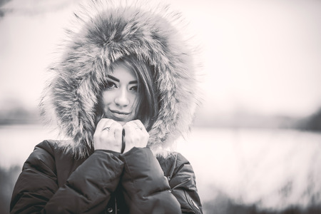 Young pretty sexy lady outdoor with forest and frozen lake on background, black and whiteの写真素材