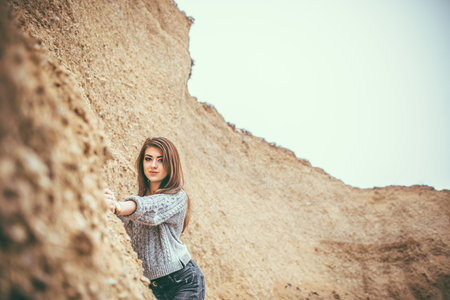 Pretty young woman outdoor in quarry with sand on backgroundの写真素材
