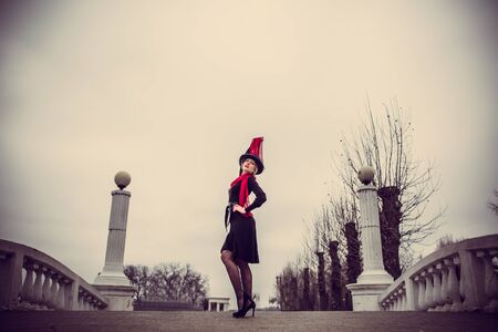 Young pretty sexy lady in black dress outdoor on the bridge with red lipsの写真素材