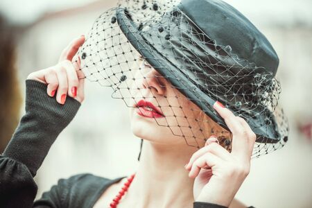 Young pretty sexy lady in black vinntage hat outdoor with red lipsの写真素材