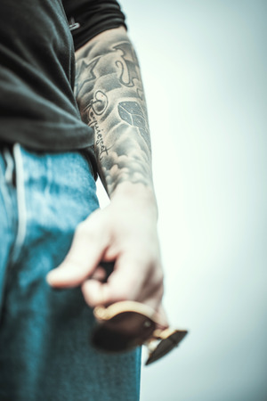 Man with tattoo on the top of the high building with cityscape on backgroundの写真素材