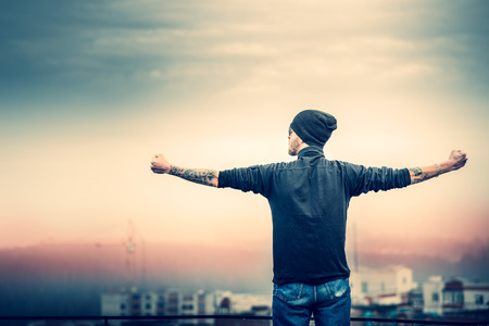 Man with beard on the top of the high building with cityscape on backgroundの写真素材