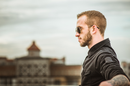 Man with beard on the top of the high building with cityscape on backgroundの写真素材