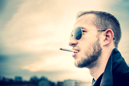 Man with beard on the top of the high building with cityscape on backgroundの写真素材