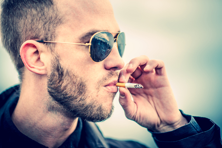 Man with beard on the top of the high building with cityscape on backgroundの写真素材