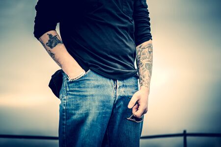 Man with tattoo on the top of the high building with cityscape on backgroundの写真素材