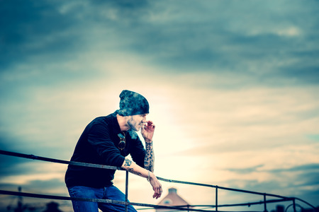 Man with beard on the top of the high building with cityscape on backgroundの写真素材