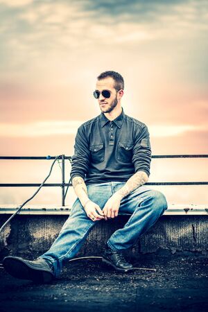 Man with beard on the top of the high building with cityscape on backgroundの写真素材