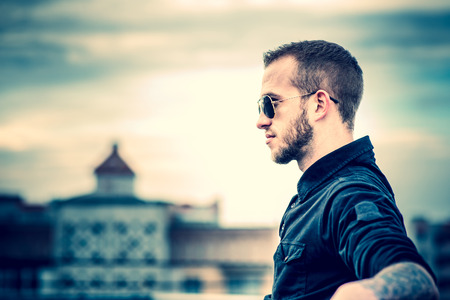 Man with beard on the top of the high building with cityscape on backgroundの写真素材