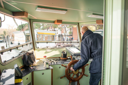 Man driving theboat, photo behind the driver in the cabin