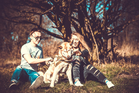 Girlfriend with her boyfriend outdoor in the forest with husky