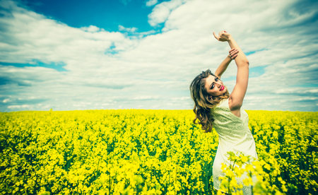 One pretty girl walking in the yellow field