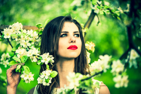 One pretty girl in the garden under the blossom apple treeの写真素材