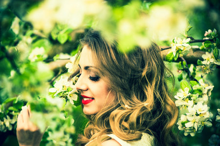 One pretty girl in the garden under the blossom apple tree