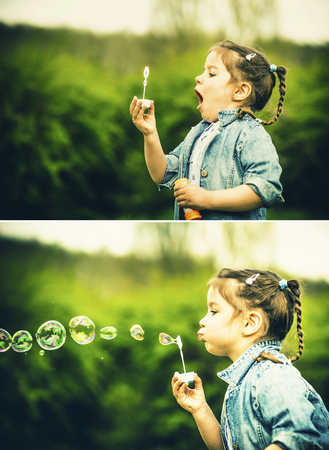 Little happy pretty girl blowing bubbles outdoor in the parkの写真素材