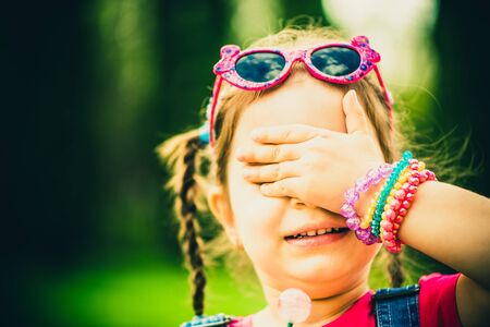 Little girl with lollipop outdoor in the parkの写真素材