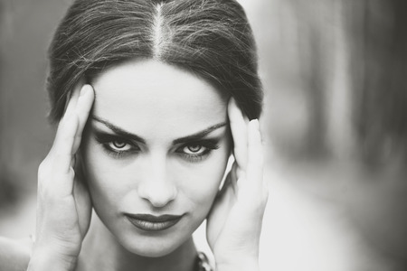Pretty brunette girl touch her head, showing headacheの写真素材