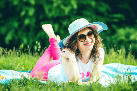 Pretty girl lying on the grass outdoor in the parkの写真素材