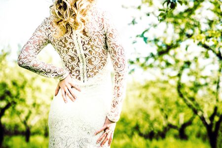 Portrait of a beautiful bride outdoor in the park, back viewの写真素材