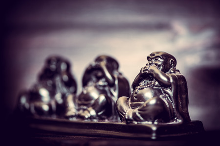 Three figures of Buddha philosophy on wooden backgroundの写真素材