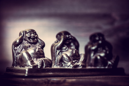 Three figures of Buddha philosophy on wooden backgroundの写真素材