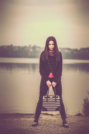 Long hair brunette girl with lake on backgroundの写真素材