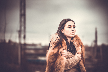 Pretty long hair brunette girl with old industrial view behind, grain effectの写真素材