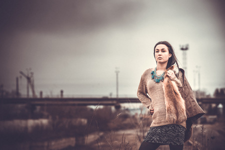Pretty long hair brunette girl with old industrial bridge behind, grain effectの写真素材