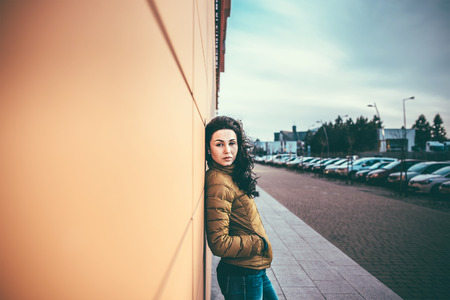 Girl on the city street near wall with long hairの写真素材