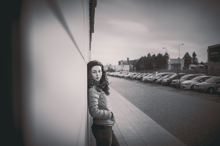 Girl on the city street near wall with long hairの写真素材