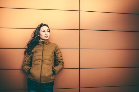 Girl on the city street near wall with long hairの写真素材