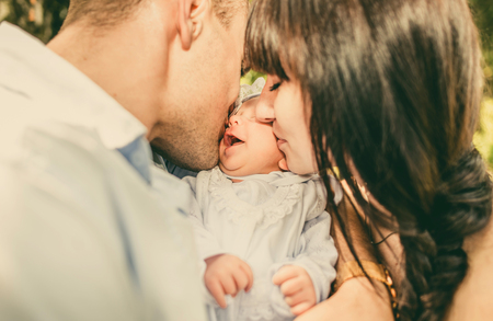 Mother and father with her newborn baby outdoor in the parkの写真素材