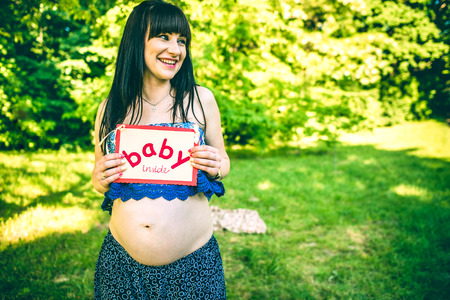Pregnant woman in dress outdoor in the parkの写真素材