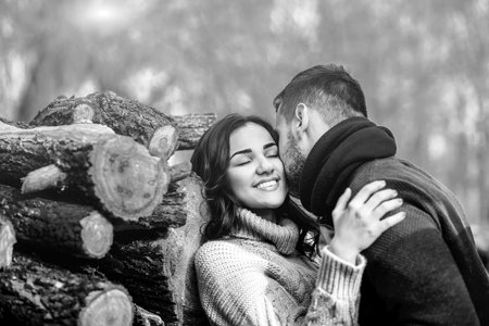 Pretty young couple outdoor near wooden stockの写真素材