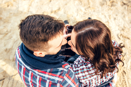 Pretty young couple sitting on the beachの写真素材