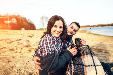 Pretty young couple sitting on the beachの写真素材