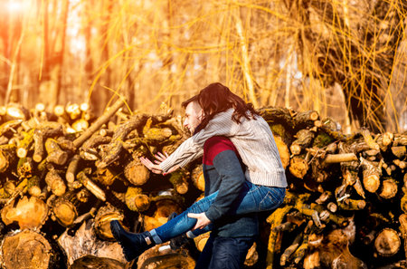 Pretty young couple outdoor near wooden stockの写真素材