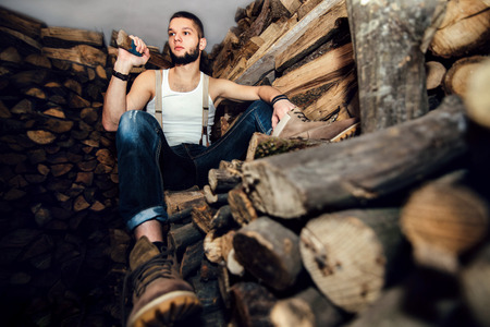 Man with ax in hands near firewood stockの写真素材