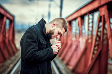 Young man with beard walking on the railwayの写真素材
