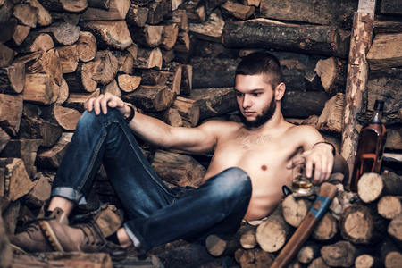Man with ax in hands near firewood stockの写真素材