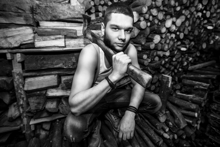 Man with ax in hands near firewood stockの写真素材