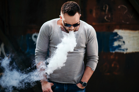 Men with beard vaping outdoor in sunglassesの写真素材