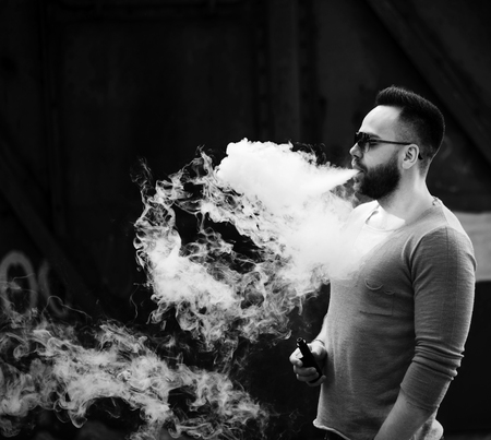 Men with beard vaping outdoor in sunglassesの写真素材