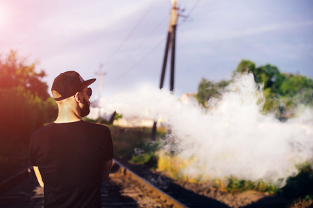 Men with beard vaping outdoor in sunglassesの写真素材