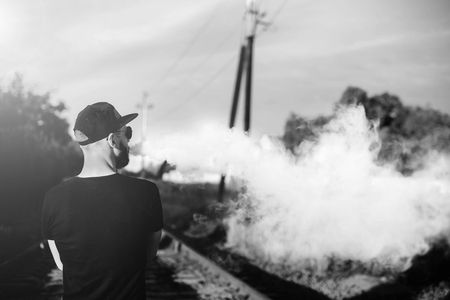 Men with beard vaping outdoor in sunglassesの写真素材