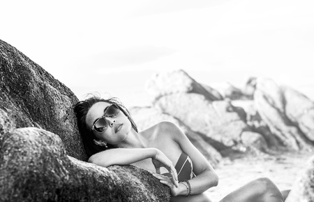 Pretty brunette girl relaxing on the stonesの写真素材