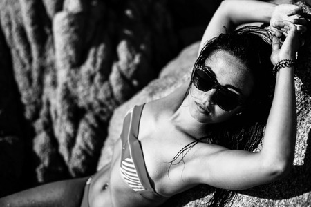 Pretty brunette girl relaxing on the stonesの写真素材
