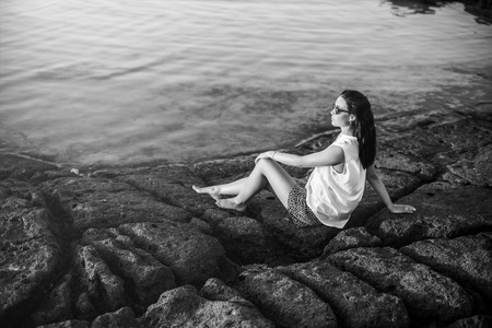Long hair brunette girl relaxing in the stonesの写真素材