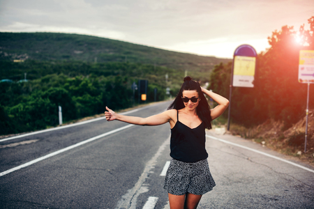Long hair brunette tourist girl walking on the roadの写真素材