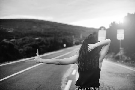 Long hair brunette tourist girl walking on the roadの写真素材